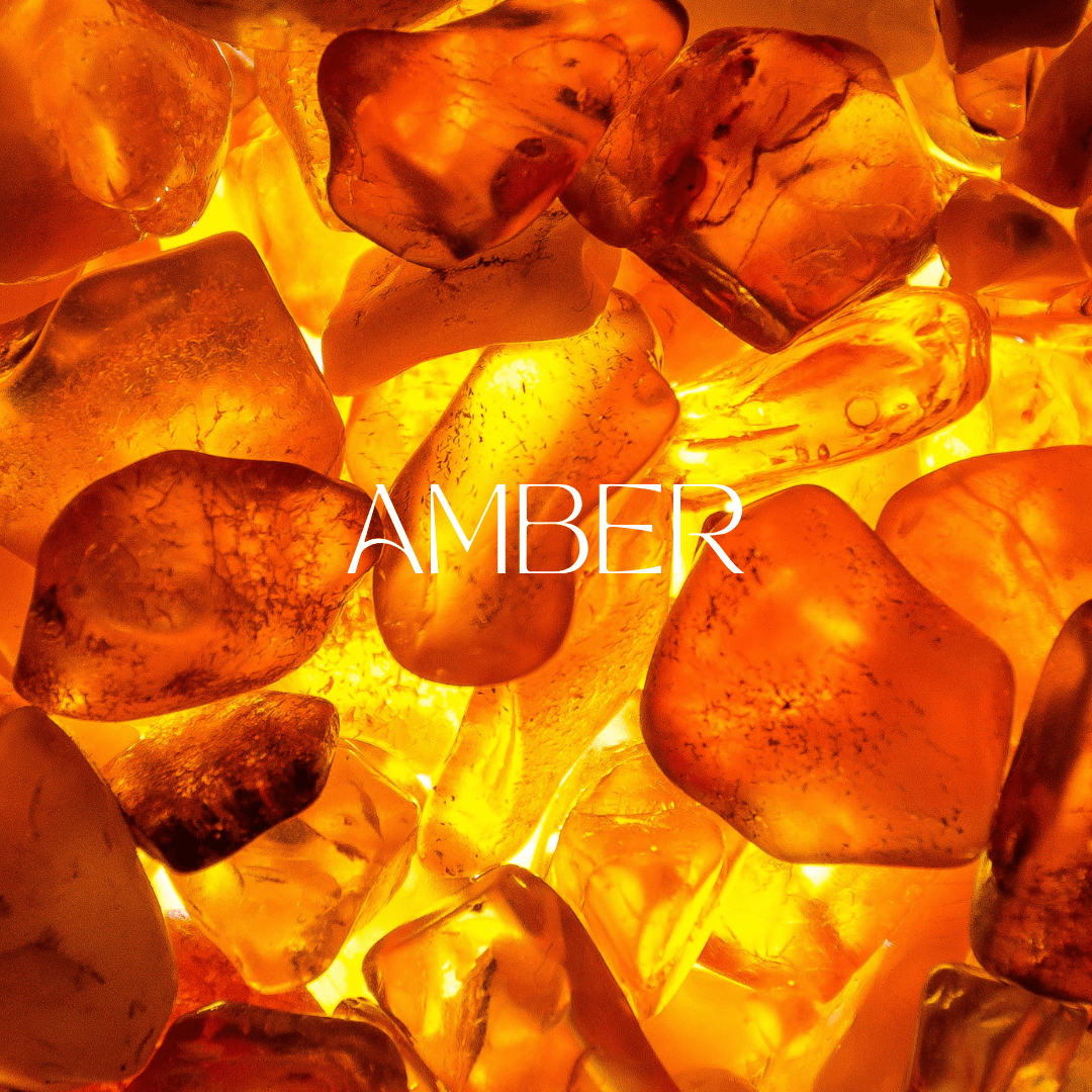 Close-up of polished golden amber stones with glowing light, showcasing the rich texture and warm color used in luxury perfumes.